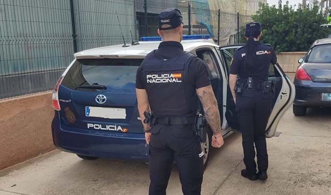 Agentes de la Policía Nacional frente a un coche patrulla.